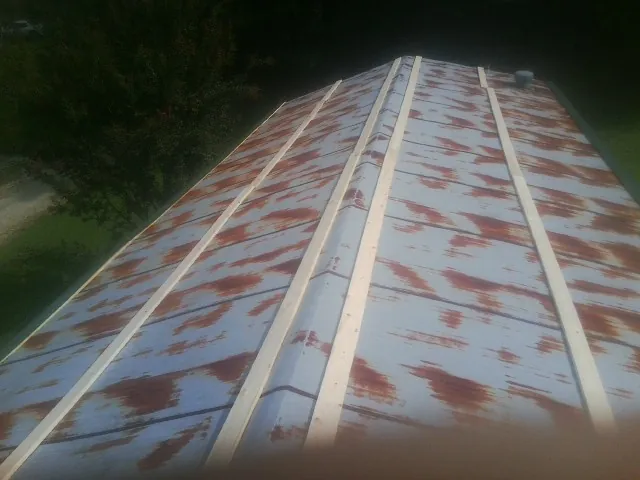 Rusted metal roof panels with new wood purlins before replacement — Storm Damage Roof Repair in Peaks Island by Roofing Brothers