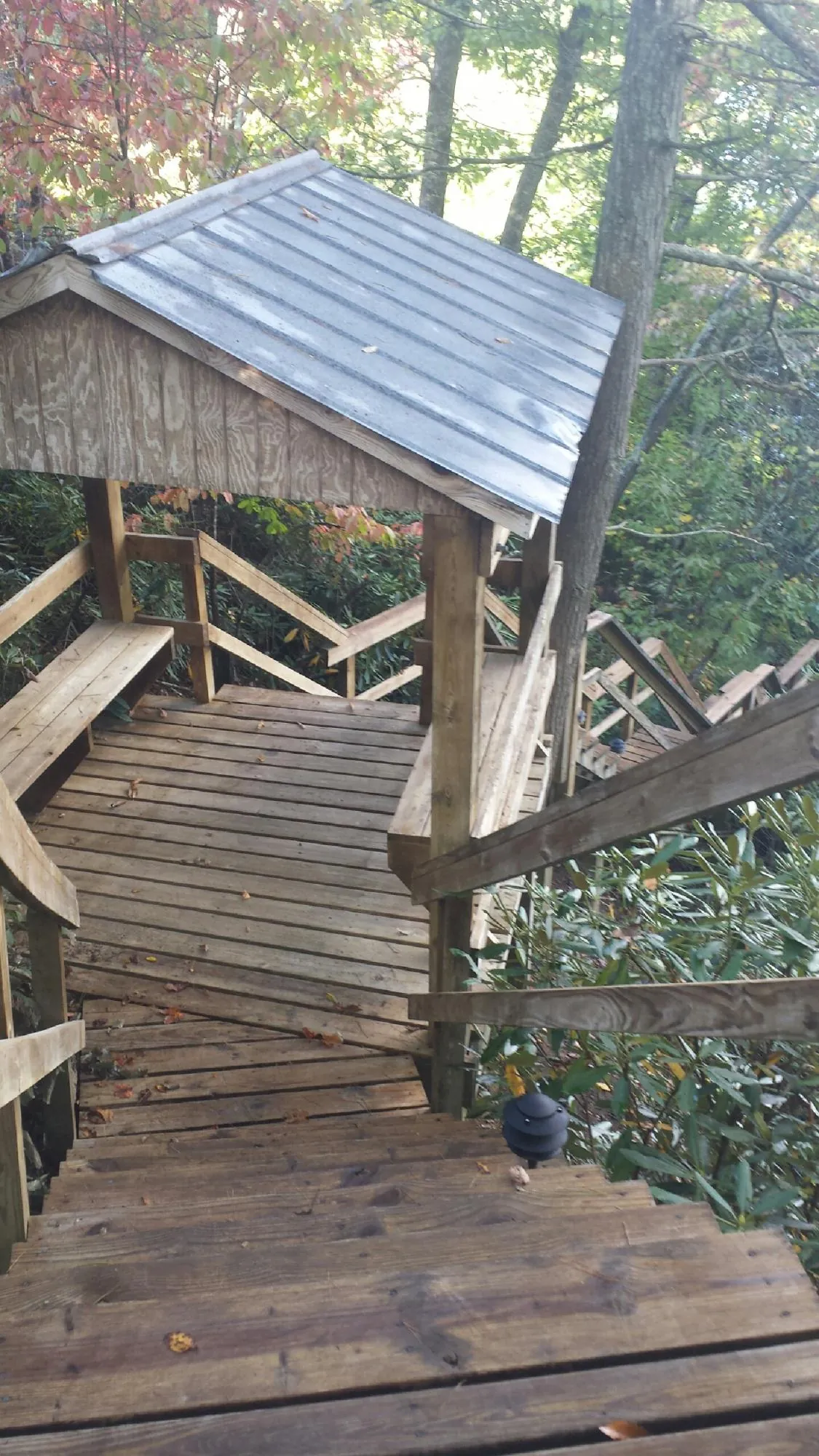 Metal roofed shelter over wooden steps on a wooded walkway — Skylight Repair & Installation work by our crew in Peaks Island