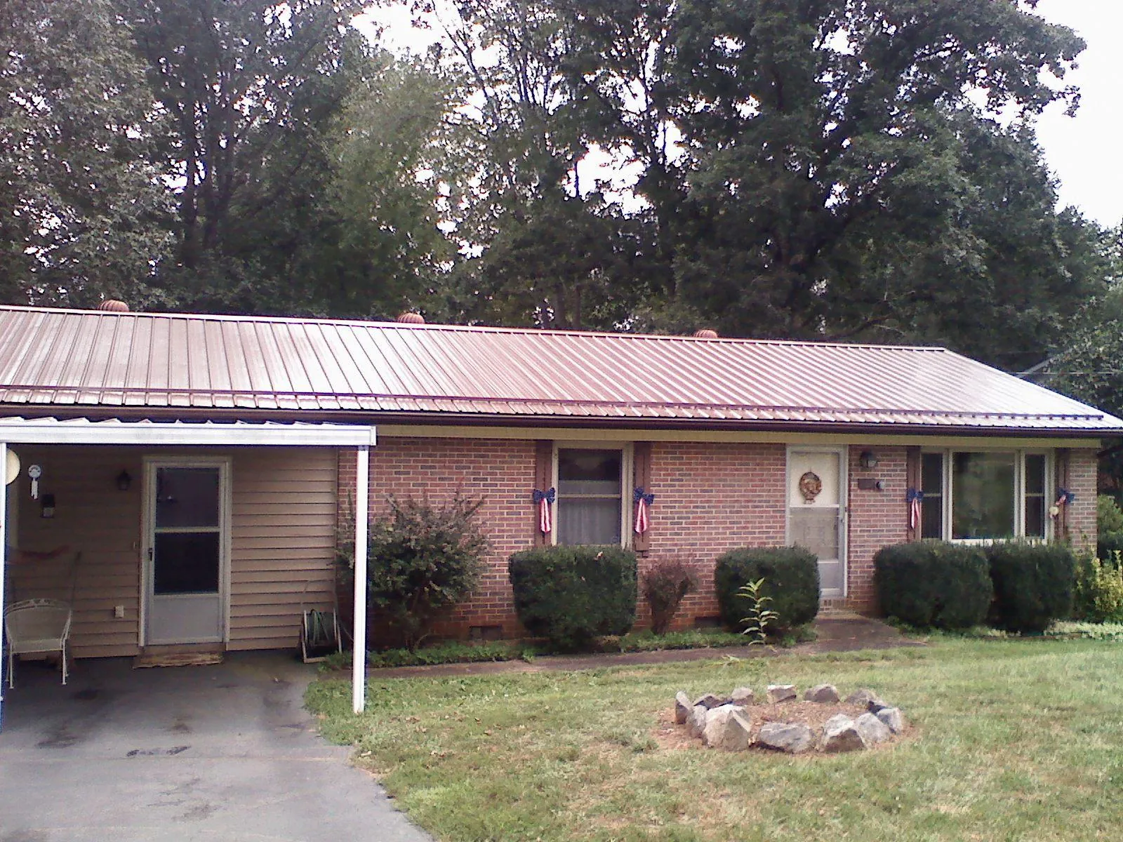 Bronze metal roof and carport on a brick ranch home — Roof Repair work by our crew in Peaks Island